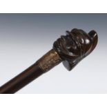 An early 20th century walking stick, with a carved wooden handle in the form of a military figure in