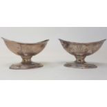 A pair of early 19th century oval silver pedestal salts, crested, marks rubbed, 5.7 ozt