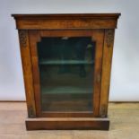 A 19th century walnut and marquetry inlaid pier cabinet, having a glazed door, on a plinth base,