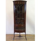 A 19th century mahogany corner cabinet, with two glazed doors, and three drawers, on splayed legs