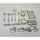 A George V silver card case, four white metal spirit labels, a cigarette case, four salt spoons, two