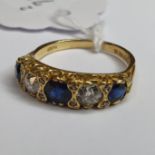 An 18ct gold, sapphire and diamond three stone ring, in a pierced setting, ring size N 1/2