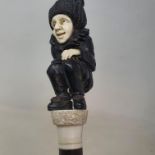 A 19th century walking stick, with an ivory and ebony handle, comically carved showing a crouched