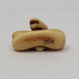 An early 20th century carved ivory netsuke, in the form of a bean, 3 cm wide