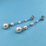 A pair of white gold and graduated pearl drop earrings
