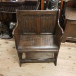 An oak hall chair, with a linen fold panel back