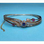 An early 20th century rose gold, sapphire, ruby and diamond bangle, in leather presentation box