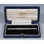 A 1920's silver coloured metal and diamond line brooch, in presentation blue leather box, with