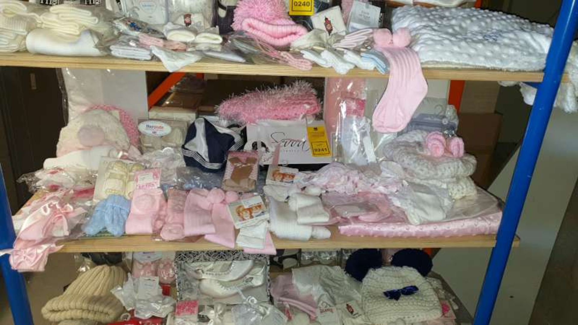 SHELF CONTAINING CHILDRENS CLOTHING AND ACCESSORIES IN VARIOUS STYLES AND SIZES