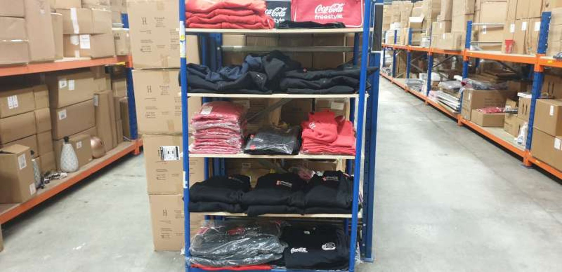 STAND CONTAINING A LARGE QTY OF COCA COLA BRANDED CLOTHING IN VARIOUS STYLES