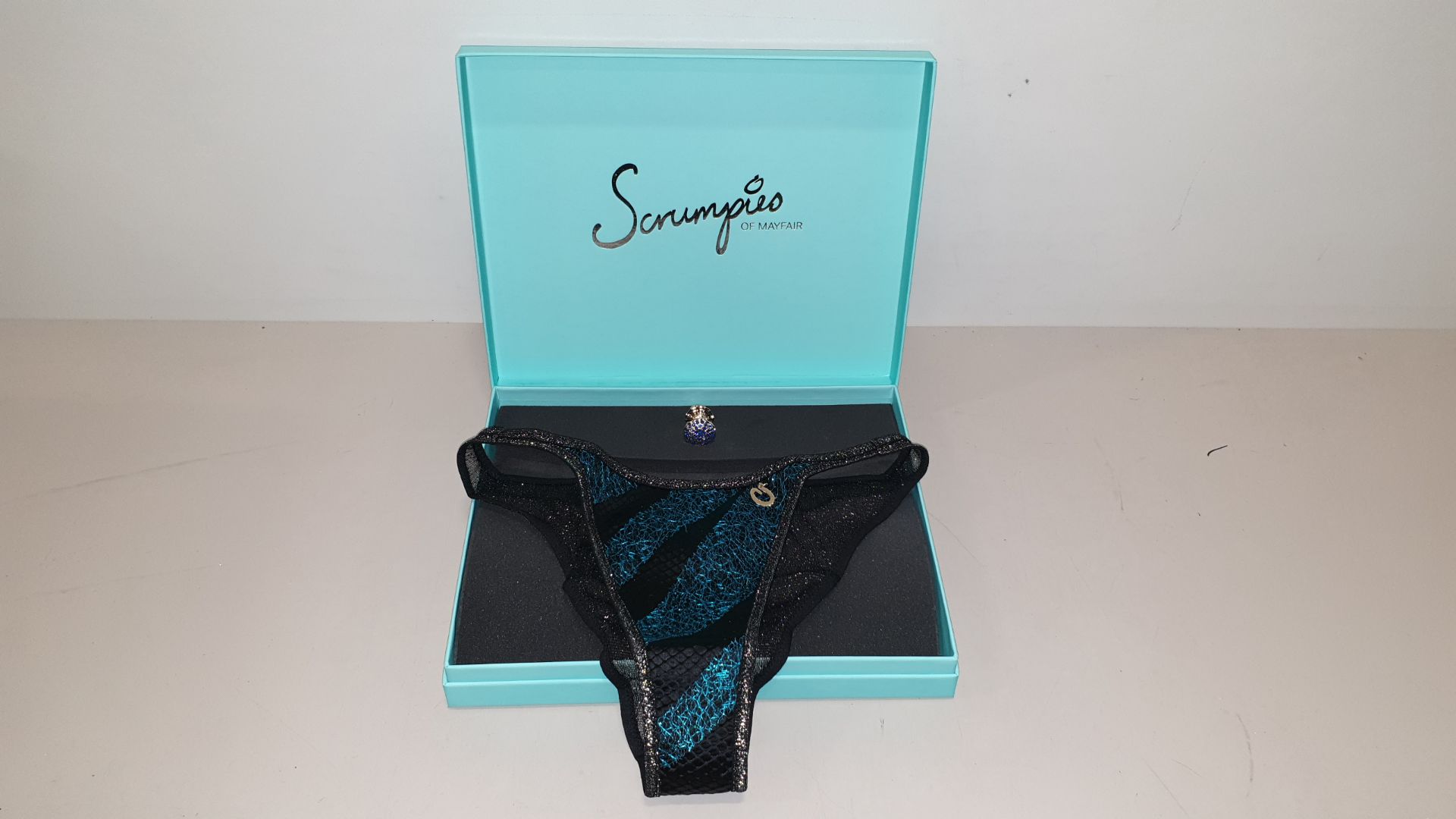 50 X SCRUMPIES OF MAYFAIR DRAGONSNAP ICE TANGA BRIEFS - SIZES 8-16 (1-5) WITH BAG OF 50 CHARMS AND