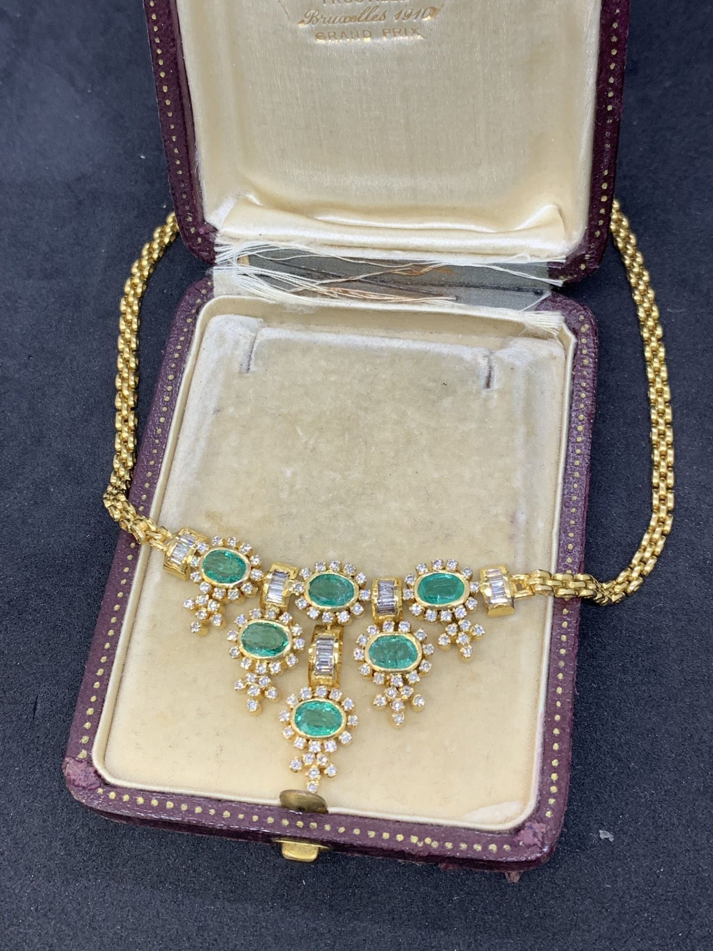 18 carat gold necklace set with emeralds and baguette diamonds weighs 32 g