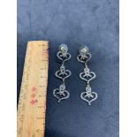 Diamond is a triple heart drop earrings set in silver
