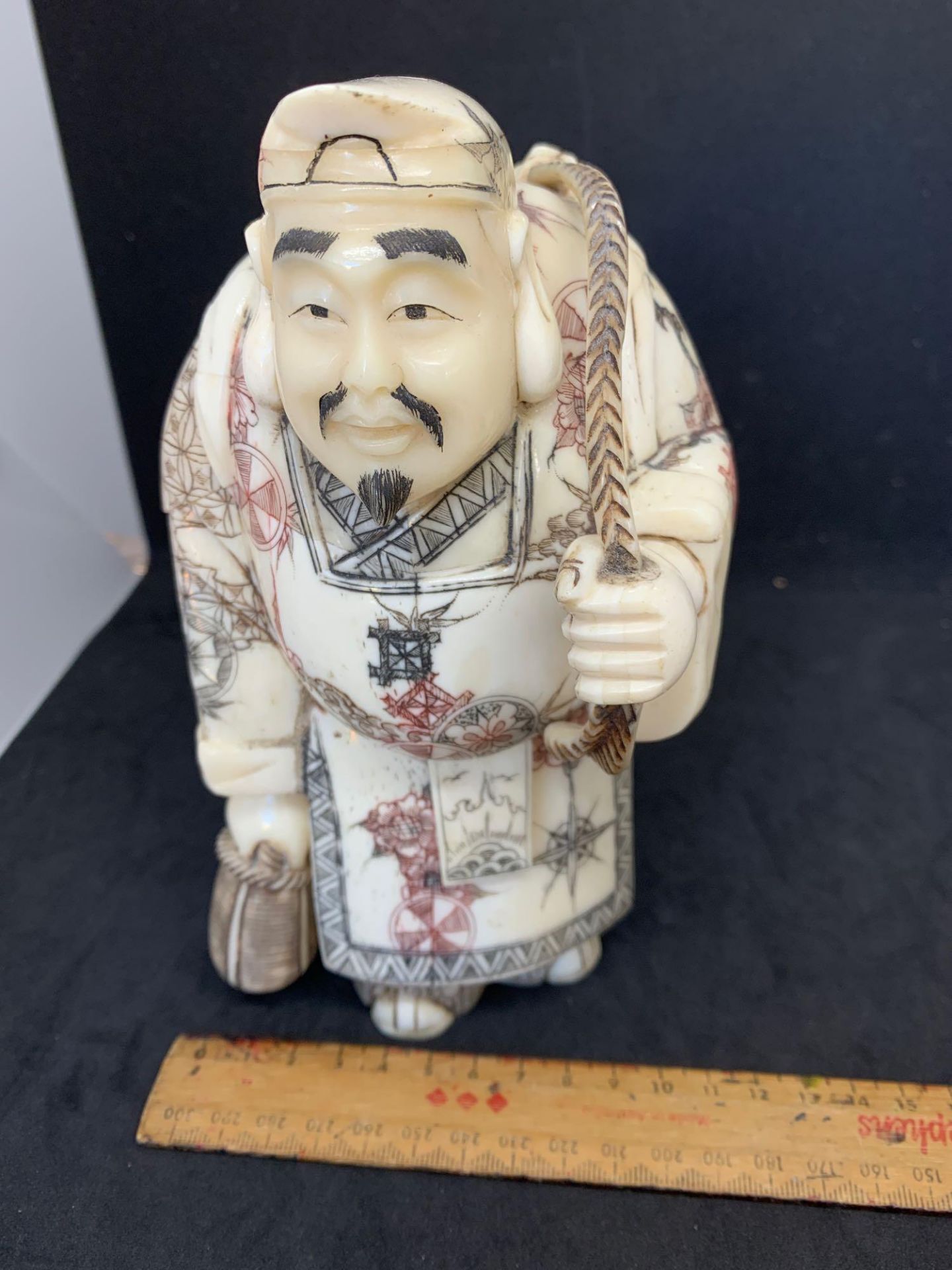 Chinese or Japanese looking figure of a man carrying fish signed on the bottom