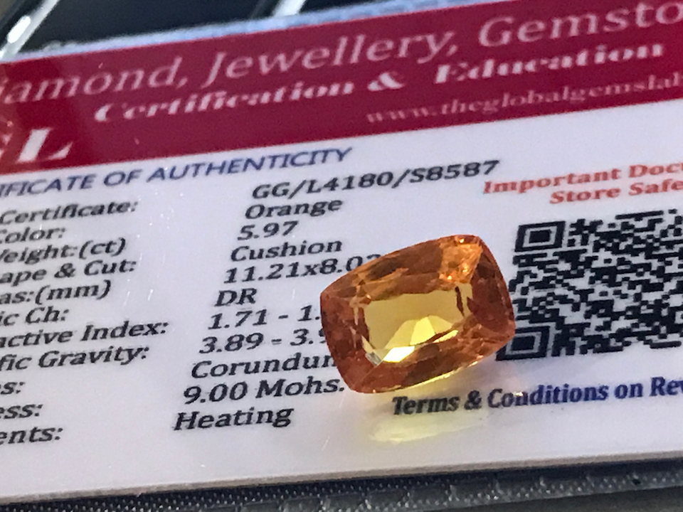 ORANGE STONE WITH CARD MARKED SAPPHIRE