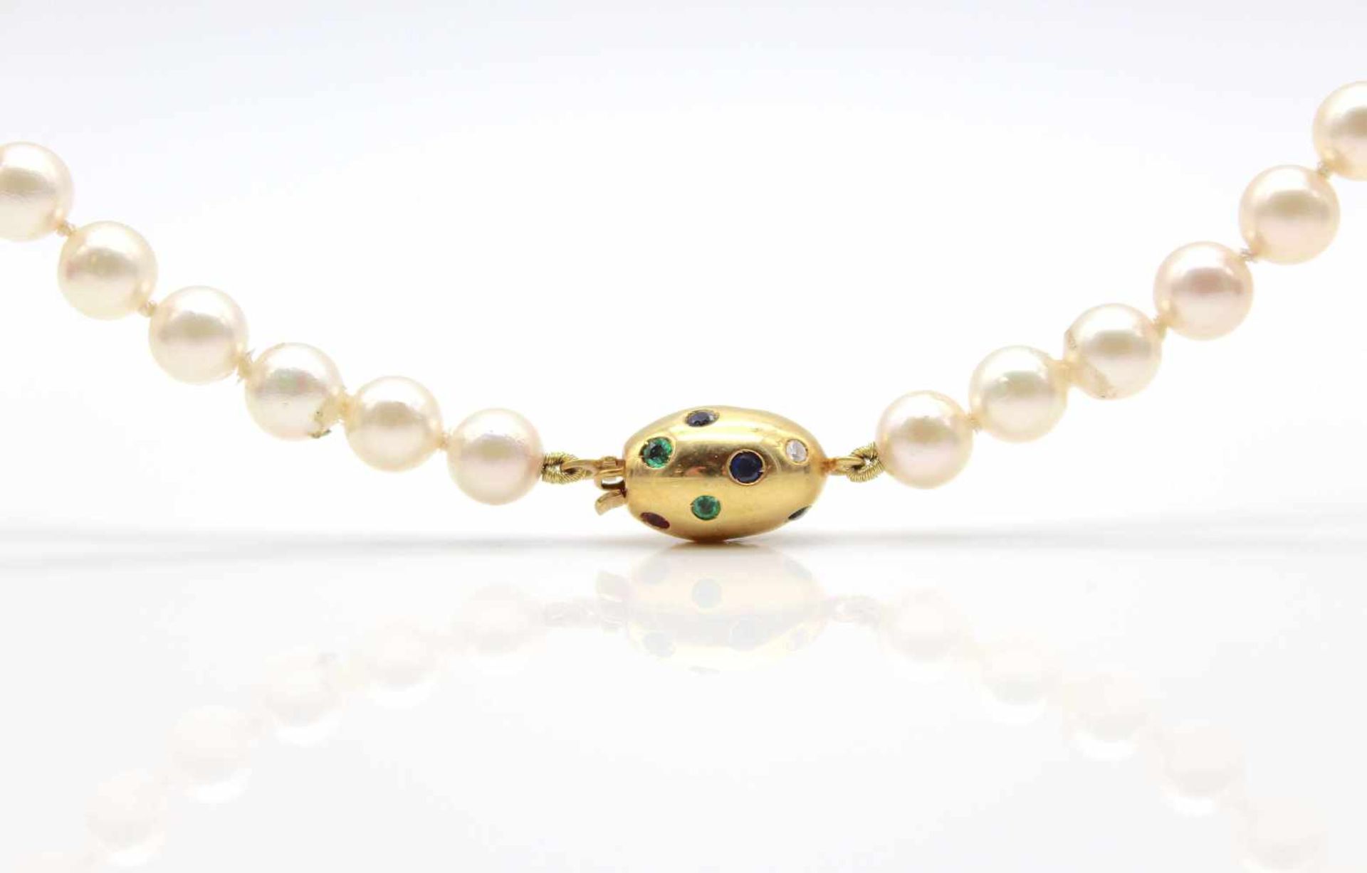 Cultured pearl necklace with a 750 gold lock with ruby, sapphire and emerald.Weight 54 g, length