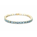 Armband aus 585er Gelb- und Weißgold mit 30 blauen Topasen, gesamt ca. 15 ct. Gewicht: 16,2 g,