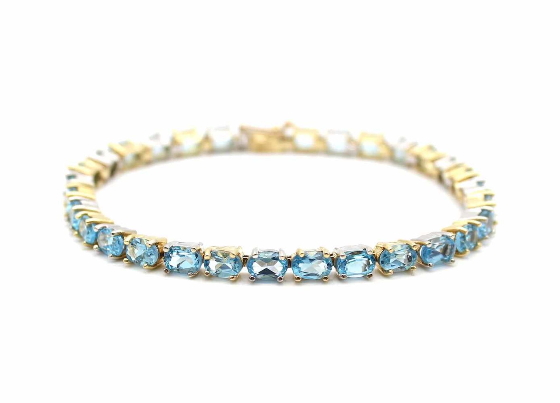 Armband aus 585er Gelb- und Weißgold mit 30 blauen Topasen, gesamt ca. 15 ct. Gewicht: 16,2 g,