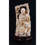 An early 20th century Chinese ivory figure depicting a scholar sat with a tiger. 21cm 8.25ins high.