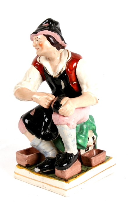 A Staffordshire pottery figure in the form of a cobbler, 31cms (12.75ins) high.