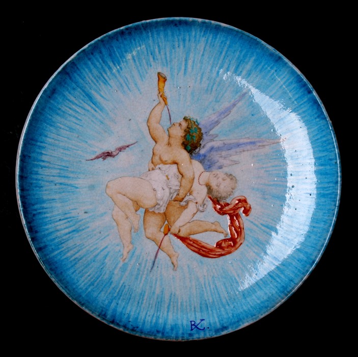 A Theodore Deck ceramic dish decorated with an angel and maiden, initialled 'TD' and numbered 1861