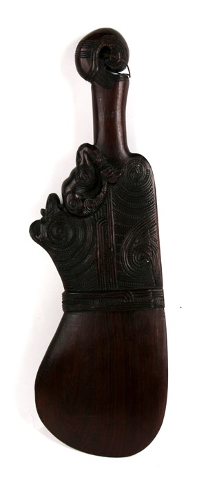 A Maori Wahaika hardwood war club carved with a full figure tiki and further geometric carving,