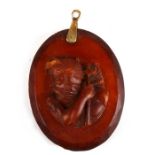 A 19th century facet cut amber pendant carved with a portrait of Neptune. Weighs 14.2g. 5 by 4cm ( 2