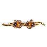 A large brooch of both 9ct and 18ct gold, set with two cabochon tiger eye stones. Possibly a pair of