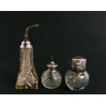 Two cut glass perfume atomisers with silver tops, the largest 20cms (8ins) high; together with