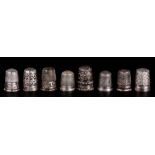 A group of silver & white metal thimbles.