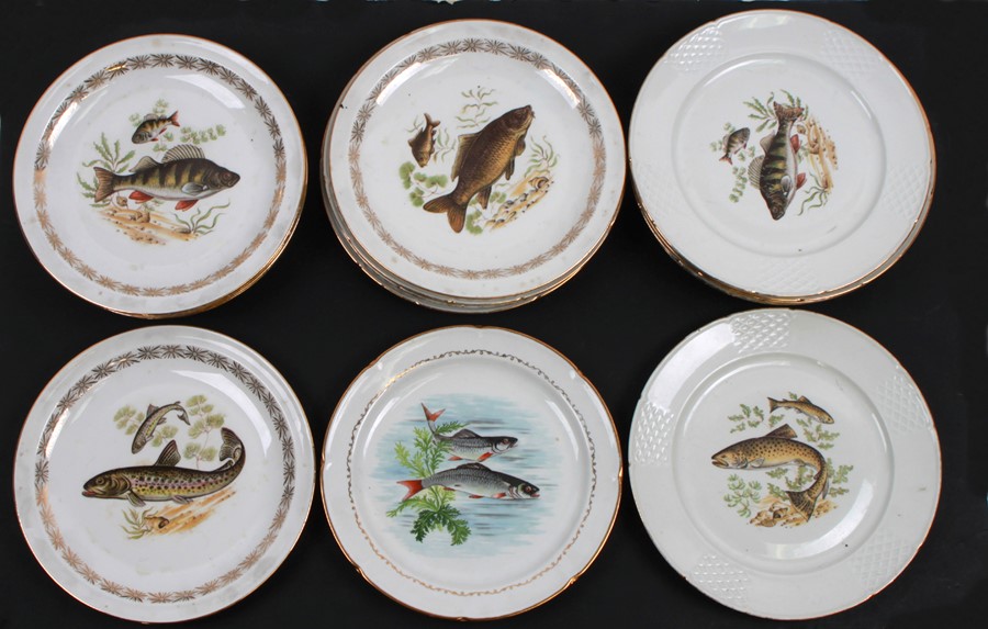 A quantity of Limoges plates, each decorated with fish within a gilded border, 24cms (9.5ins)
