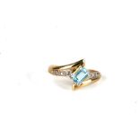 A 9ct gold ring set with a square cut blue topaz and diamond set shoulders, approx UK size 'O'.