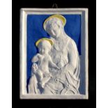 An Italian majolica plaque depicting the Madonna and Child, 28 by 38cms (11 by 15ins).