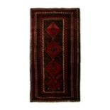 A Persian Kurdish woollen hand knotted rug with repeated diamond medallions within borders, on a