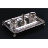 A Victorian silver desk stand with two silver mounted cut glass inkwells and central candlestick,