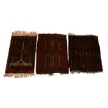 Two Persian Balouch woollen hand knotted mats; together with a similar Afghan mat, the largest 60.