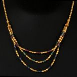 A 14ct gold bead necklace with ruby, emerald and sapphire beads, total weight 24.4g.