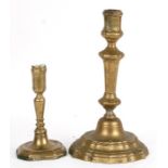 An 18th century brass candlestick, 26cms (10ins) high; together with another similar smaller,