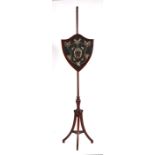 A Regency mahogany pole screen with shield shaped screen having a silk embroidered panel.