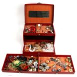 A quantity of costume jewellery in a red jewellery box.