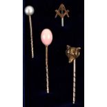 A group of antique stick pins to include 9ct gold Masonic, coral and fox head examples.