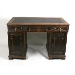 An early 20th century oak pedestal writing desk with an arrangement of three drawers and two