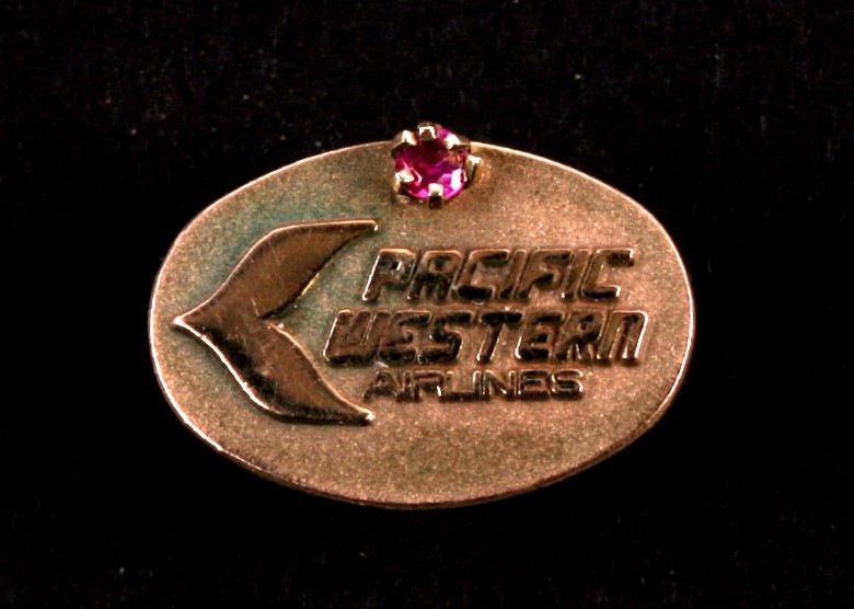 A 10ct gold Pacific Western Airlines air stewardess pin badge set with a single ruby.