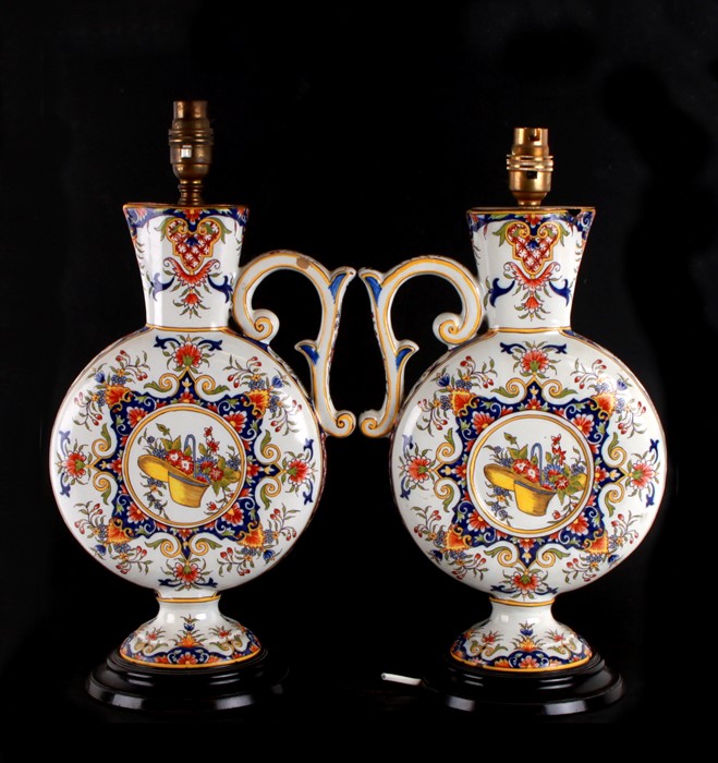 A pair of coloured Delft moon flask ewers, converted and fitted as table lamps, mounted on wooden