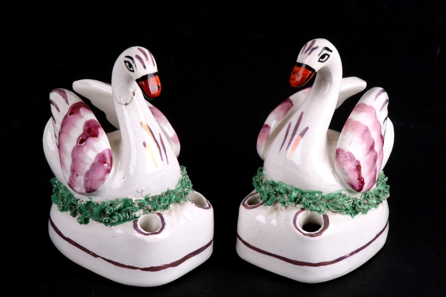 A pair of mid 19th century pink lustre swan quill holder inkwells, each depicted seated upon a nest.