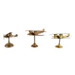 Three cast brass WW1 biplane models with spinning propellers on their brass stands. The largest