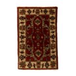 An Afghan woollen hand knotted rug with three central guls within foliate borders on a beige ground,