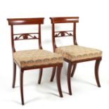 A pair of Regency mahogany dining chairs on sabre front supports.