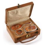 A 1920's leather cased silver and tortoiseshell vanity set to include brush, hand mirror and pill