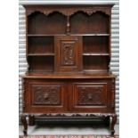 An oak dresser, the plate rack with central cupboard carved with a dragon above two further